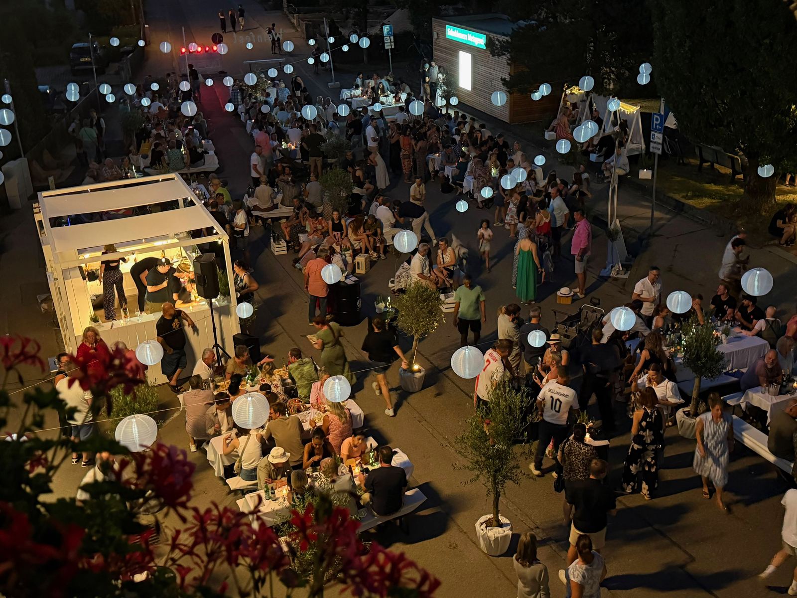 Abendstimmung beim ersten Pullinger Weinfest: Gäste an weiß gedeckten Tischen unter Lampions